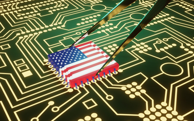 A microchip in third dimension designed to look like an American flag being placed on a circuit board using tweezers. 