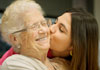 Young woman kissing grandma.